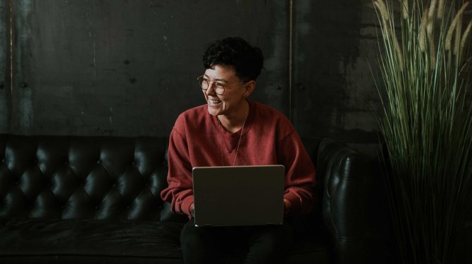 Happy woman sitting on sofa with laptop Happy woman sitting on sofa with laptop